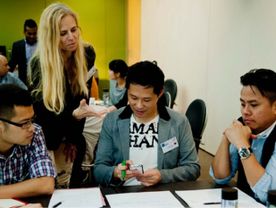 Woman teaching people around a table